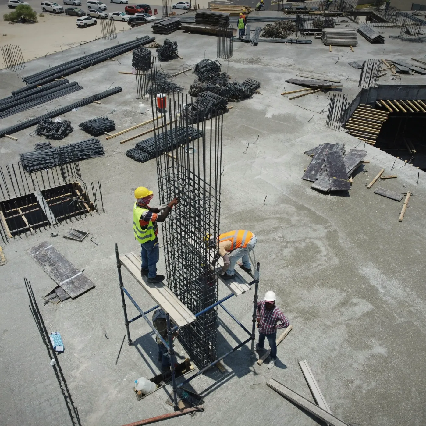 Des ouvriers assemblent les armatures d’une structure en béton sur un chantier